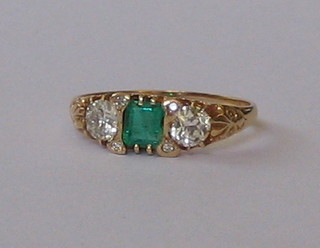 A lady's 18ct yellow gold dress ring set a square cut emerald supported by 2 diamonds