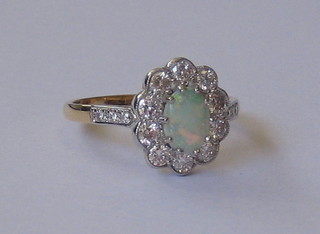 A lady's 18ct yellow gold dress ring set an oval cut opal surrounded by 10 diamonds and 6 diamonds to the shoulders