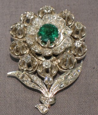 A handsome 19th Century gold brooch in the form of a flower head set an emerald approx 1.75ct, surrounded by numerous diamonds with approx. total of 3cts