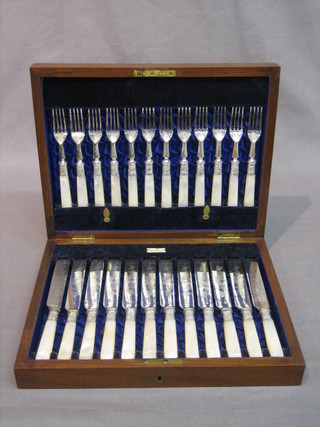 A set of 12 Victorian fruit knives and forks with silver plated blades and mother of pearl handles, contained in a walnut canteen box by Walker & Hall
