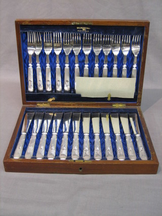 A set of 12 silver plated fish knives and forks by Walker & Hall contained in a walnut canteen box