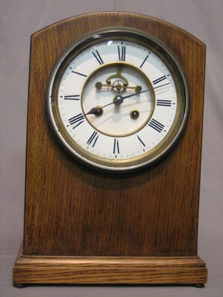 An Edwardian French 8 day striking bracket clock with porcelain dial and Roman numerals, having  a visible escapement, contained in an arch shaped oak case