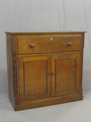 A 19th Century oak secretaire, the upper section fitted a secretaire drawer above a cupboard enclosed by panelled doors, flanked by a pair of bamboo effect columns 44"