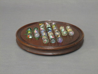 A 19th Century turned wooden circular solitaire board with 23 marbles