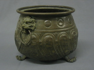 A circular embossed brass jardiniere raised on paw supports 9"
