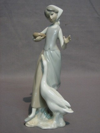 A Lladro figure of a standing lady with duck 9 1/2" (head f and r)