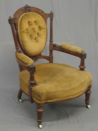 An Edwardian walnut open arm chair upholstered in orange and buttoned material