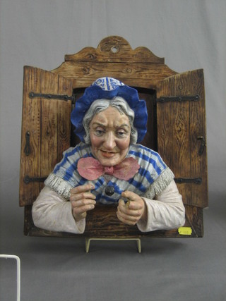 A 19th Century Continental terracotta wall plaque in the form of an elderly lady looking a through shuttered window 14" (f and r)