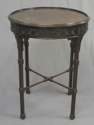A circular Chippendale style occasional table with blind fret work frieze, raised on turned column supports with X framed stretcher 21"