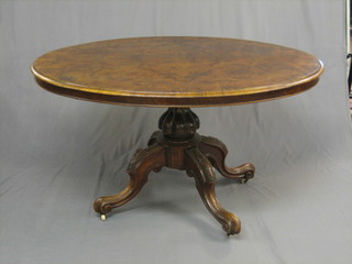 A Victorian oval figured walnut snap top Loo table, raised on carved column supports 52"