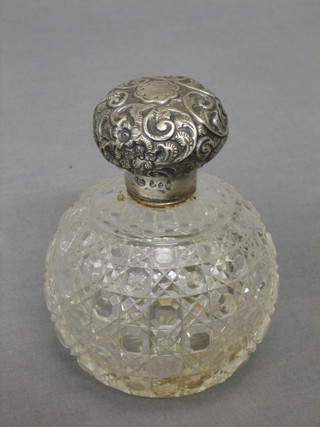A Victorian globular shaped cut glass dressing table bottle with embossed silver lid Birmingham 1899 (lid dented) 4"