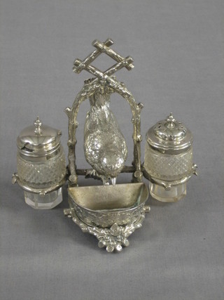 An Edwardian silver plated condiment set decorated a bird, the salt in the form of an oval feeder flanked by 2 cut glass bottles (mustard pot f)