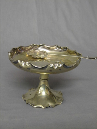 A circular silver plated comport with wavy border together with a matching spoon