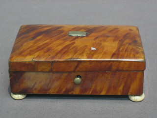 A rectangular tortoiseshell trinket box with hinged lid, raised on bun feet 4" (hinges f), containing a small collection of coins