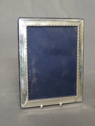 A modern plain silver easel photograph frame 7" x 5"