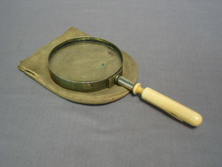 A magnifying glass with turned ivory handle