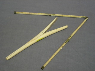A 4 fold ivory gauge 18", a pair of ivory glove stretchers and a rolling rule
