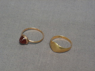 A gold signet ring and 1 other set a cabouchon cut stone