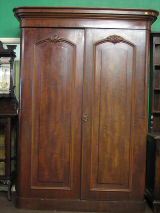 A Victorian mahogany D shaped wardrobe with moulded cornice, the interior fitted drawers enclosed by panelled doors, raised on a platform base 59"