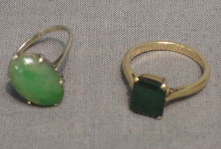 A jade coloured pendant contained in a gold mount and a green stone ring