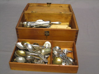 A small wooden box containing a collection of flatware