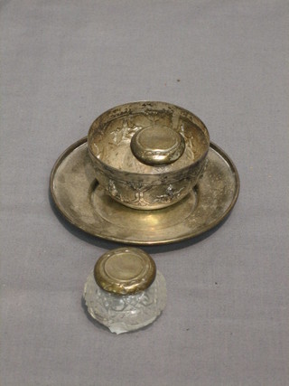 A circular Continental silver dish 4", an Eastern embossed silver bowl 2" and 2 circular cut glass dressing table jars with silver collars