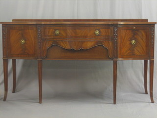 A Georgian style mahogany sideboard of serpentine outline fitted 2 long drawers flanked by a pair of cupboards, raised on splayed supports 72"