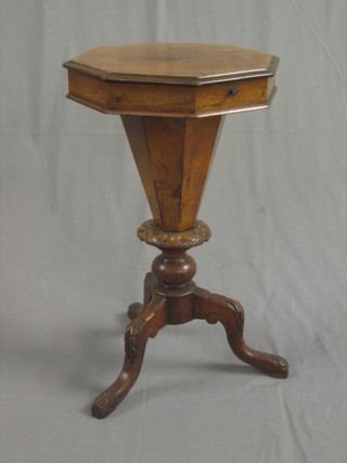 A Victorian octagonal walnut work table of conical form raised on a carved tripod base 17"