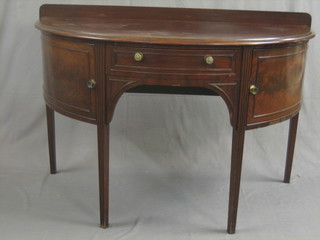 A 19th Century mahogany demi-lune side table, fitted a drawer and flanked by a pair of cupboards, raised on square reeded supports 51"