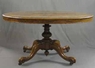 A Victorian figured walnut oval snap top Loo table raised on a carved column 54"
