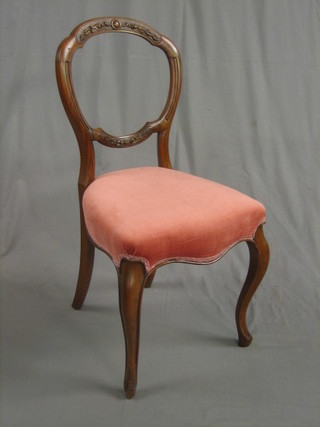 A pair of Victorian carved mahogany balloon back dining chairs with shaped mid rails and seats of serpentine outline, raised on cabriole supports upholstered in pink