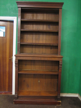 A Victorian mahogany bookcase on bookcase, the upper section with moulded cornice the interior fitted adjustable shelves with fluted columns to the side 42"