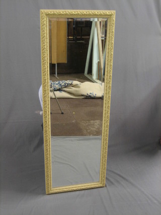A rectangular bevelled plate wall mirror contained in a decorative frame 52" x 18"