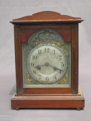 An Edwardian bracket clock with silvered dial and Arabic numerals contained in a walnut case