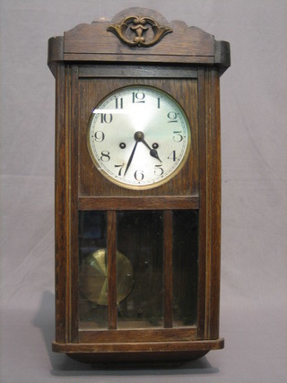 A 1930's chiming wall clock with silvered dial and Arabic numerals contained in an oak case