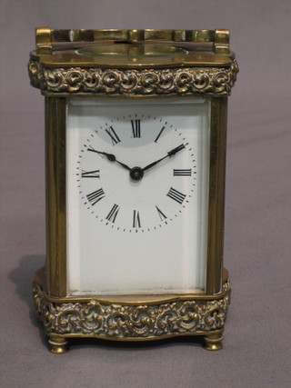 A 19th Century French 8 day carriage clock with enamelled dial and Roman numerals contained in a gilt metal case of serpentine outline (with replacement platform)