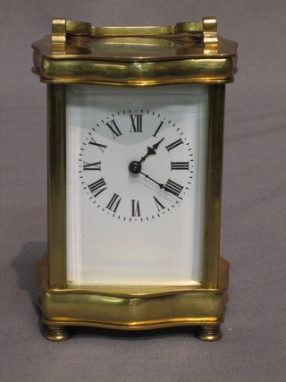 A 19th Century French 8 day carriage clock with enamelled dial and Roman numerals contained in a serpentine gilt case