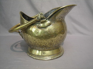 A brass helmet shaped coal scuttle