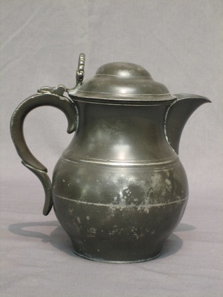 A baluster shaped pewter jug with domed cover and pierced thumb plate 9"