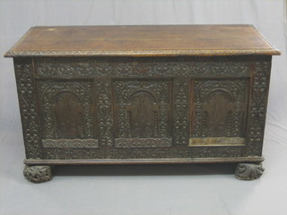 An Antique carved oak coffer of panelled construction with later hinged lid, 49"