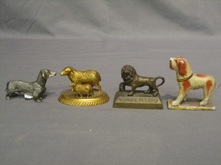 A painted wooden figure of a dog, a bronze lion marked Waterloo, a gilt metal figure of sheep and lamb and a metal figure of a dog