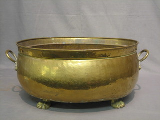 An oval twin handled brass planter raised on paw supports 20"