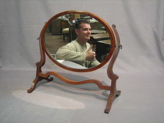 A Georgian style oval plate dressing table mirror contained in a mahogany swing frame 