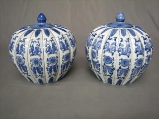A pair of 20th Century Oriental blue and white melon shaped vases and covers 7"