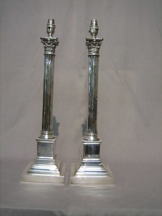 A handsome pair of modern silver plated table lamps in the form of fluted columns, raised on stepped bases with Corinthian capitals 20"
