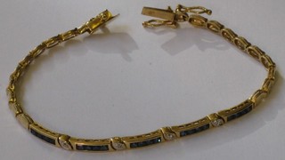 An 18ct gold bracelet set 20 square cut sapphires interspaced by 4 diamonds