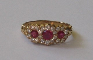 A lady's 18ct gold dress ring set 3 rubies, supported by numerous diamonds (approx 0.53ct)