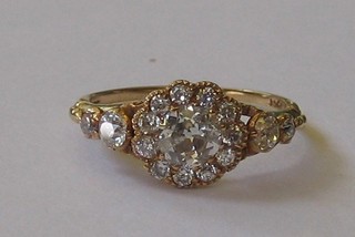 A lady's 18ct yellow gold cluster dress ring set 1 large diamond surrounded by 11 small diamonds and with 4 small diamonds to the shoulders (approx 1.17ct)