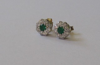 A pair of diamond and emerald cluster earrings