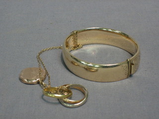 A gold plated bangle, a gold chain hung a locket and a gilt metal Russian wedding ring 